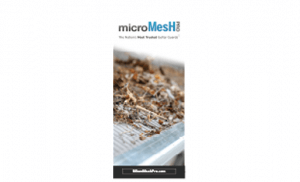 Close-up of a mesh gutter guard covered with leaves and debris. The text above reads microMesh and The Nation’s Most Trusted Gutter Guard. The bottom shows a black label with a website URL.